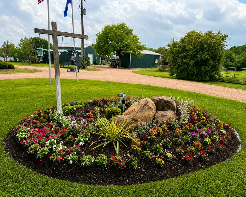Seasonal color bed with boulders at a ranch entrance