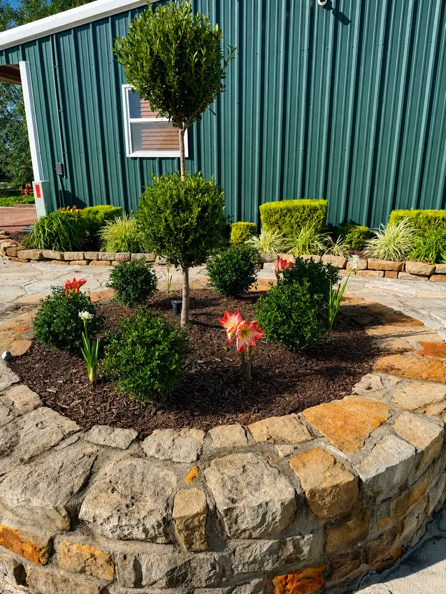 Curved bed with grasses and seasonal color beside a deck — Landscape Design & Maintenance