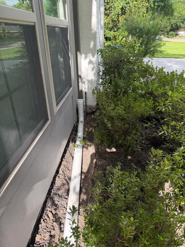 Drain line laid alongside a patio slab before backfilling — Drainage Solutions